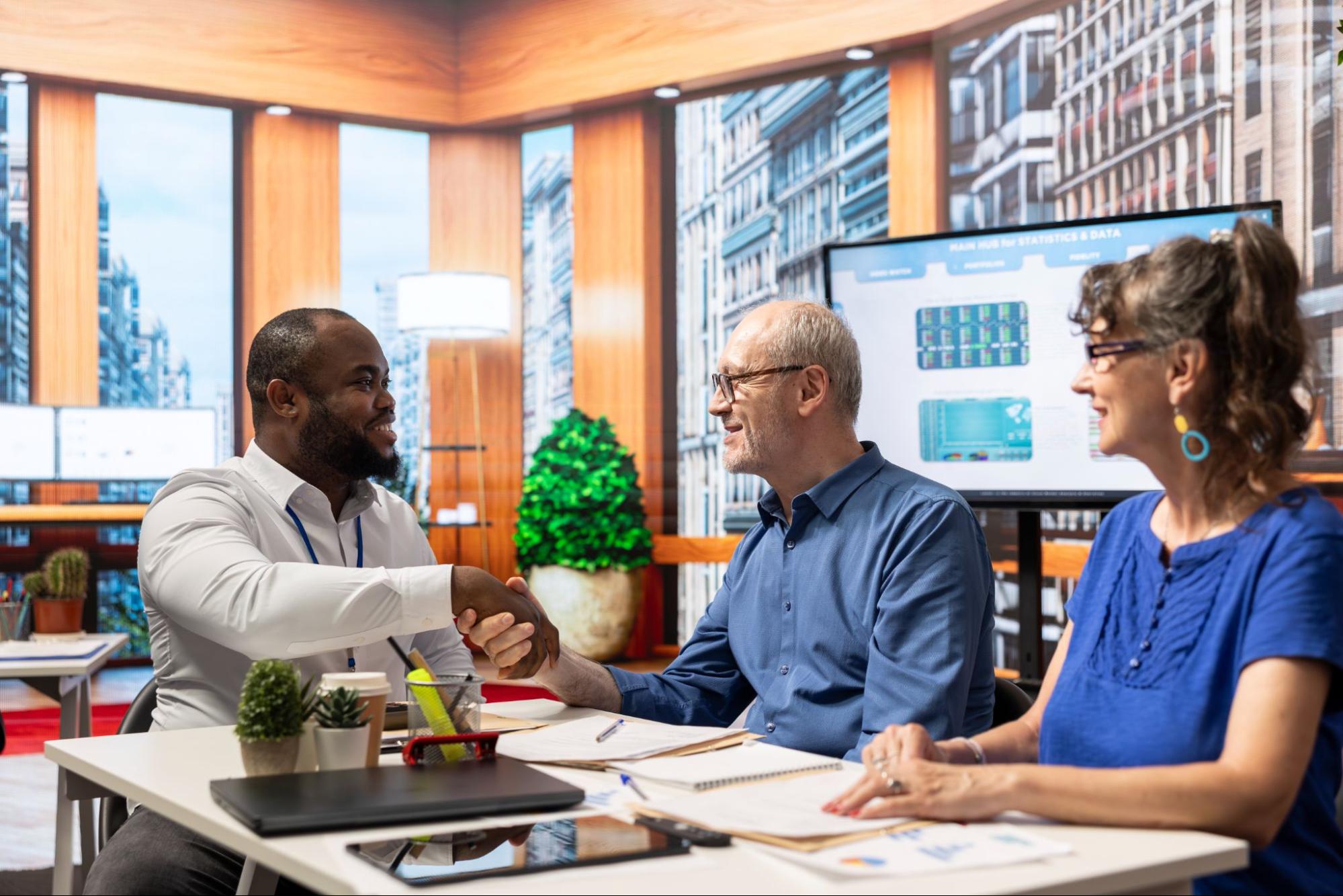 An insurance agent meets with business owners to review documents.
