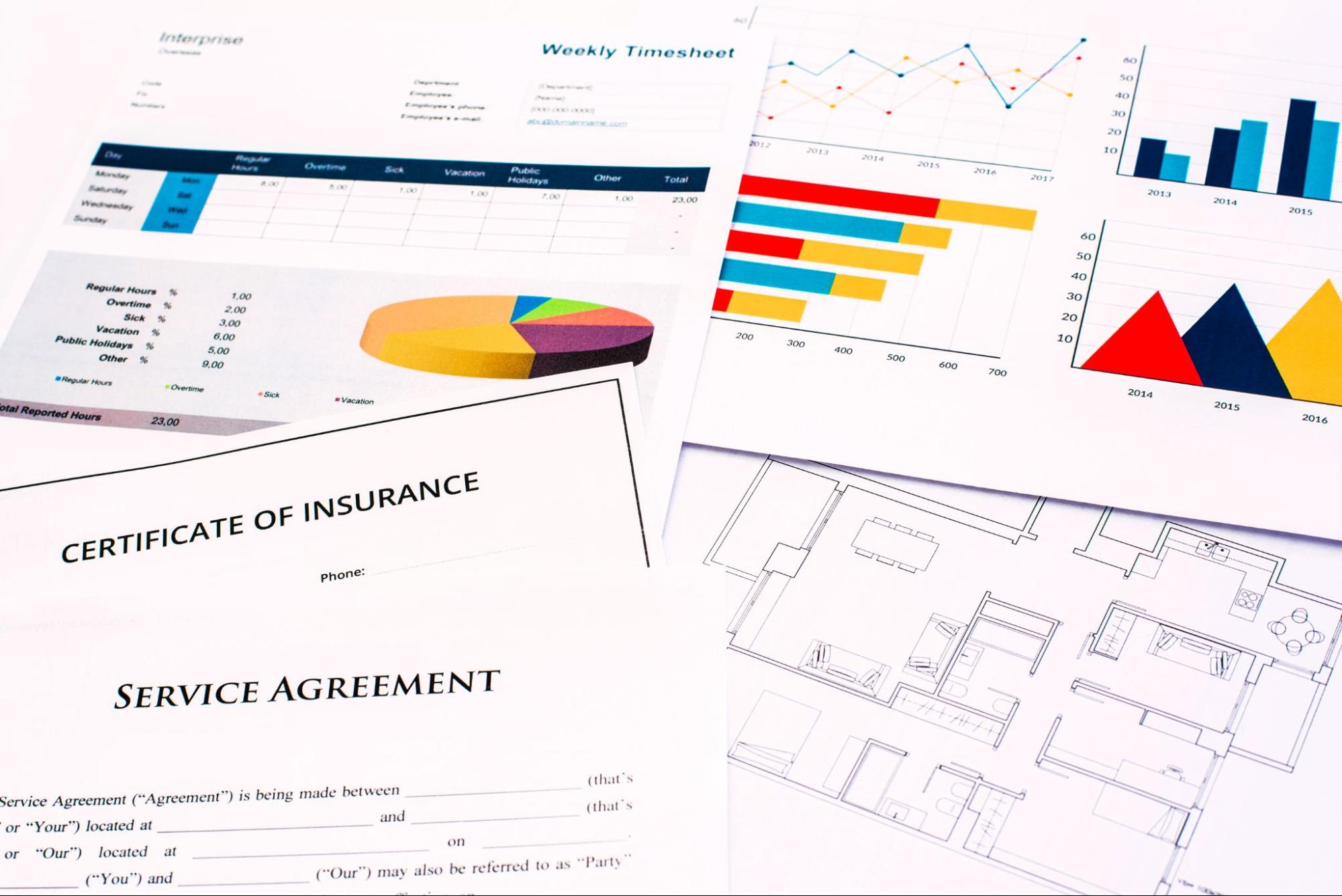 Insurance and company financial documents are scattered across a desk.