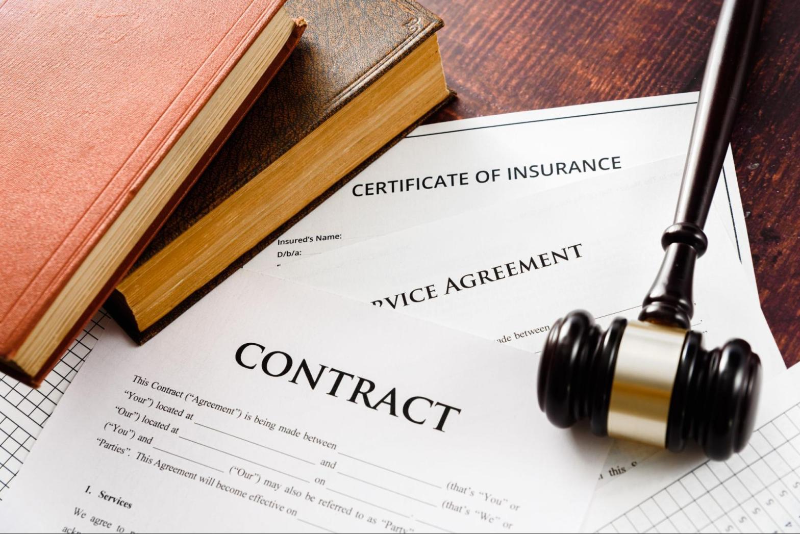 Gavel on law books with certificate of insurance, contract, and service agreement symbolizing legal compliance and surety bond protection