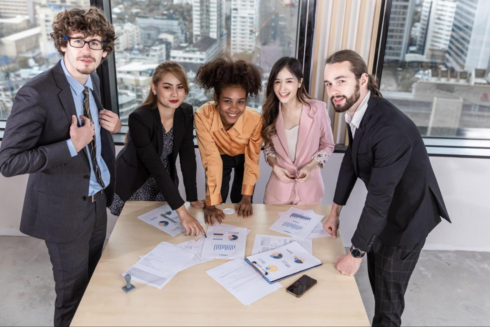 A team of business professionals review charts and graphs.