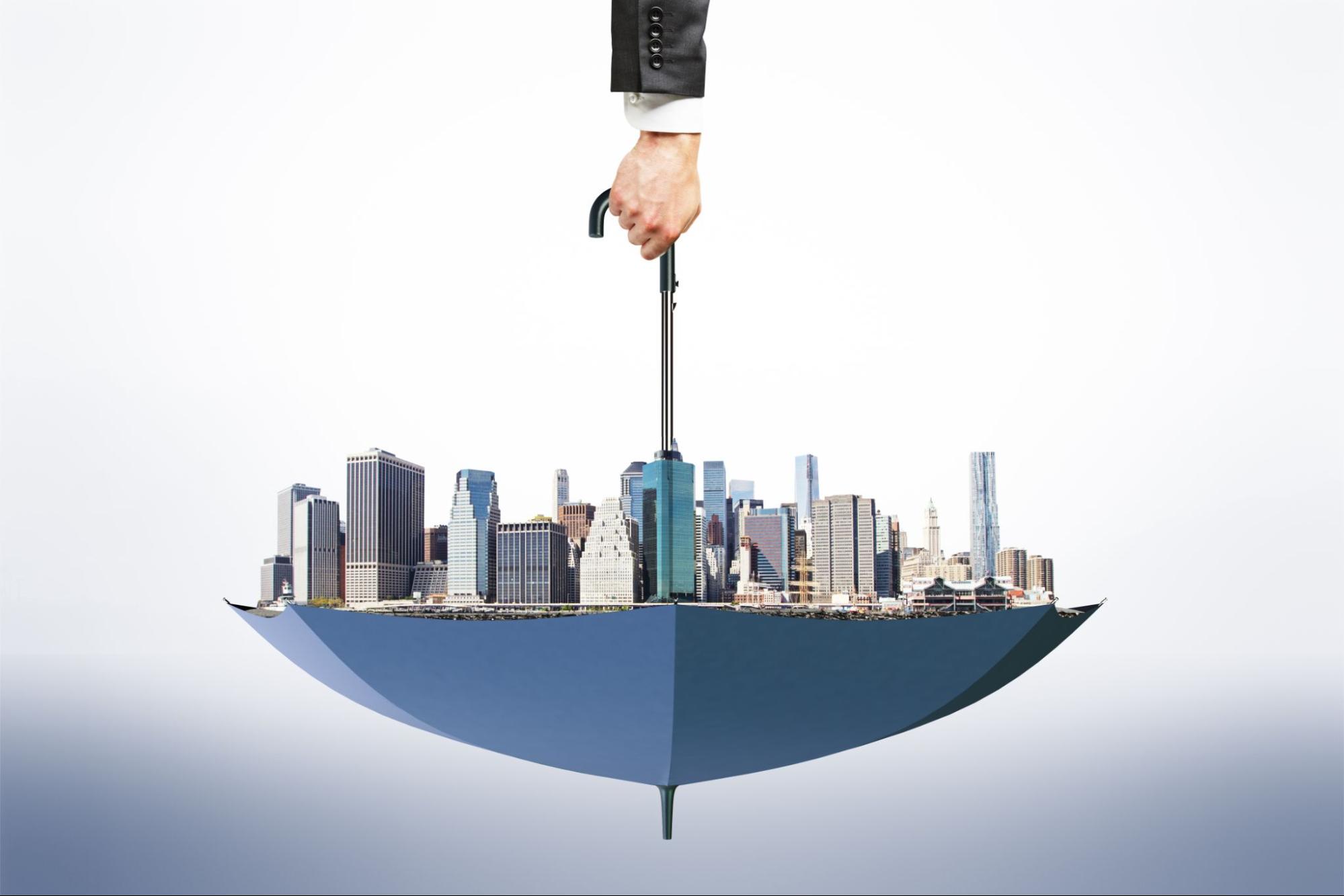 Upside-down umbrella sheltering buildings, illustrating insurance for commercial property