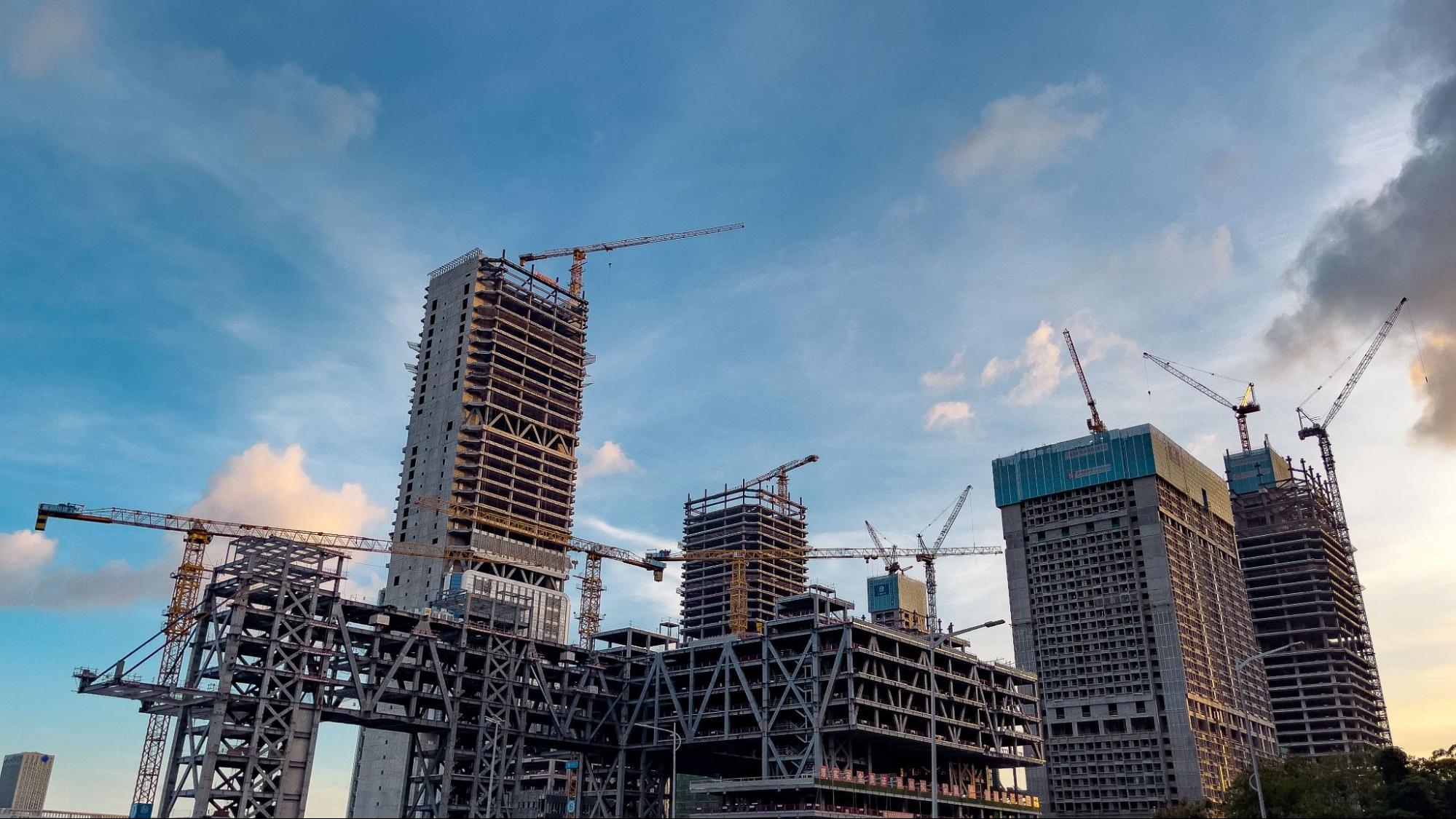 Urban skyline with cranes building modern towers in a downtown district