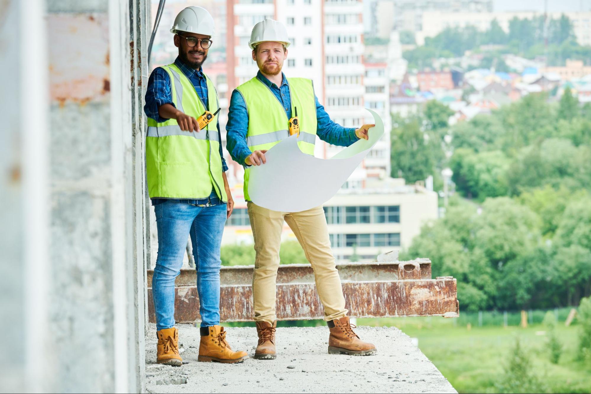 Builders reviewing construction plans at an urban building site