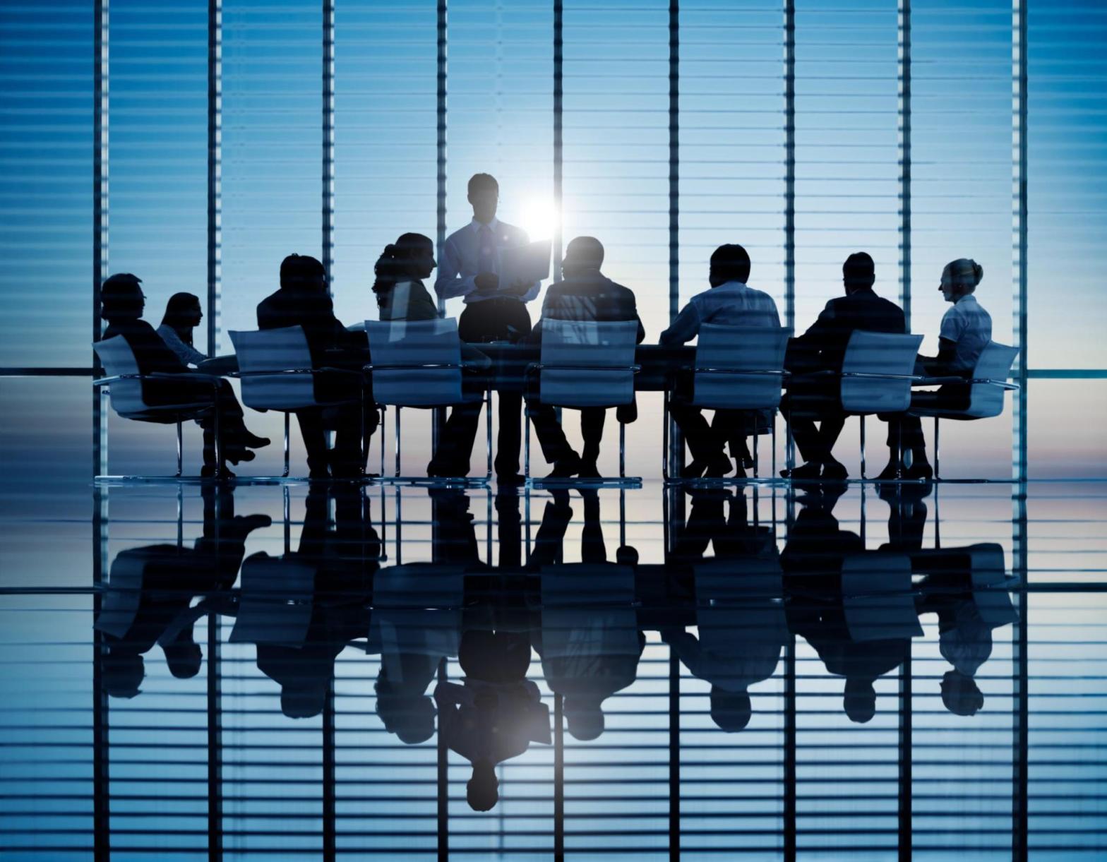 Corporate meeting in a modern glass building discussing management liability insurance protection