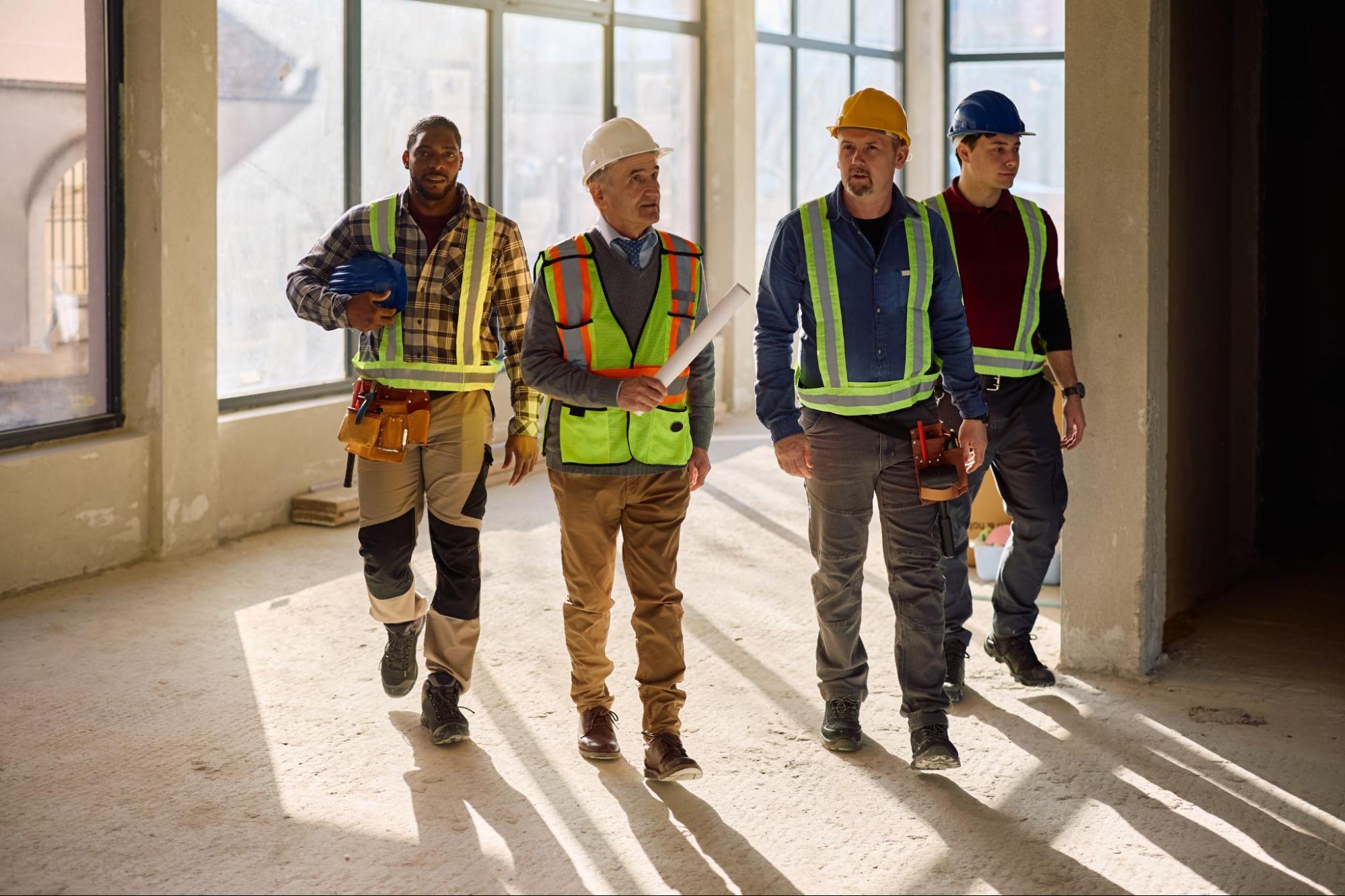 Construction workers walking through an unfinished building site